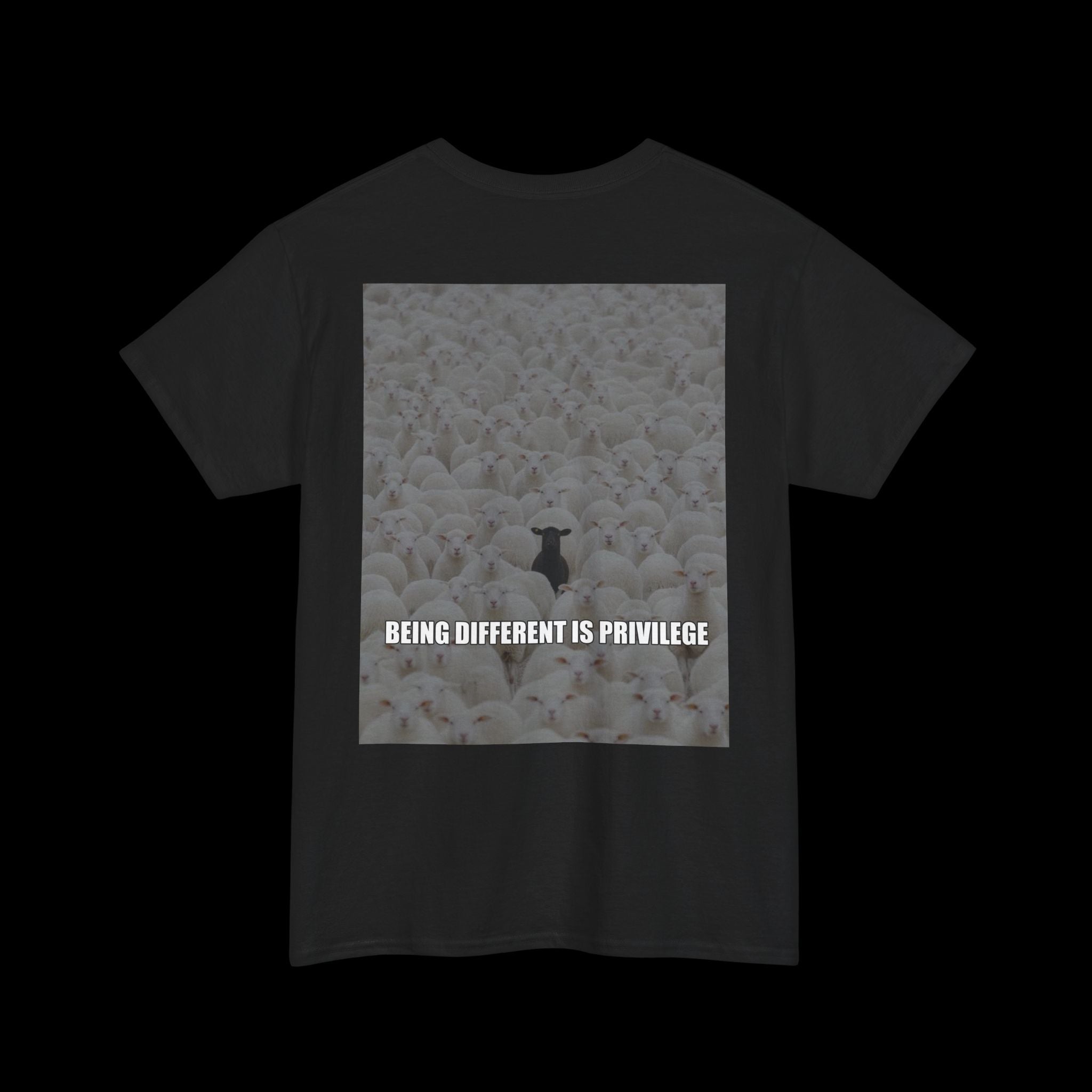 Black t-shirt featuring a graphic of a single black sheep in a flock of white sheep, with the text "BEING DIFFERENT IS PRIVILEGE" displayed below. A statement about individuality on a dark garment.